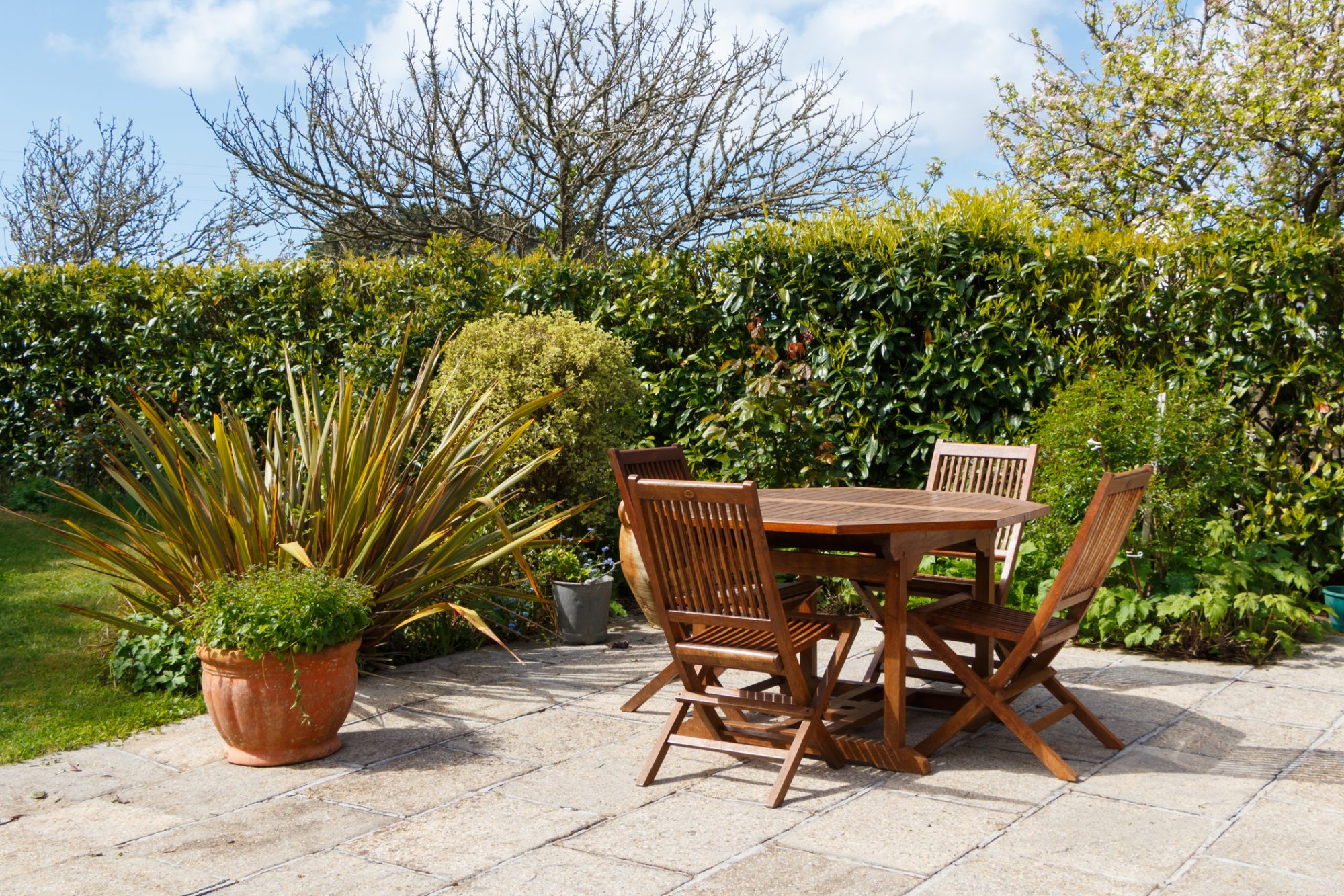 Terrace in pavement and wooden garden furniture in a garden